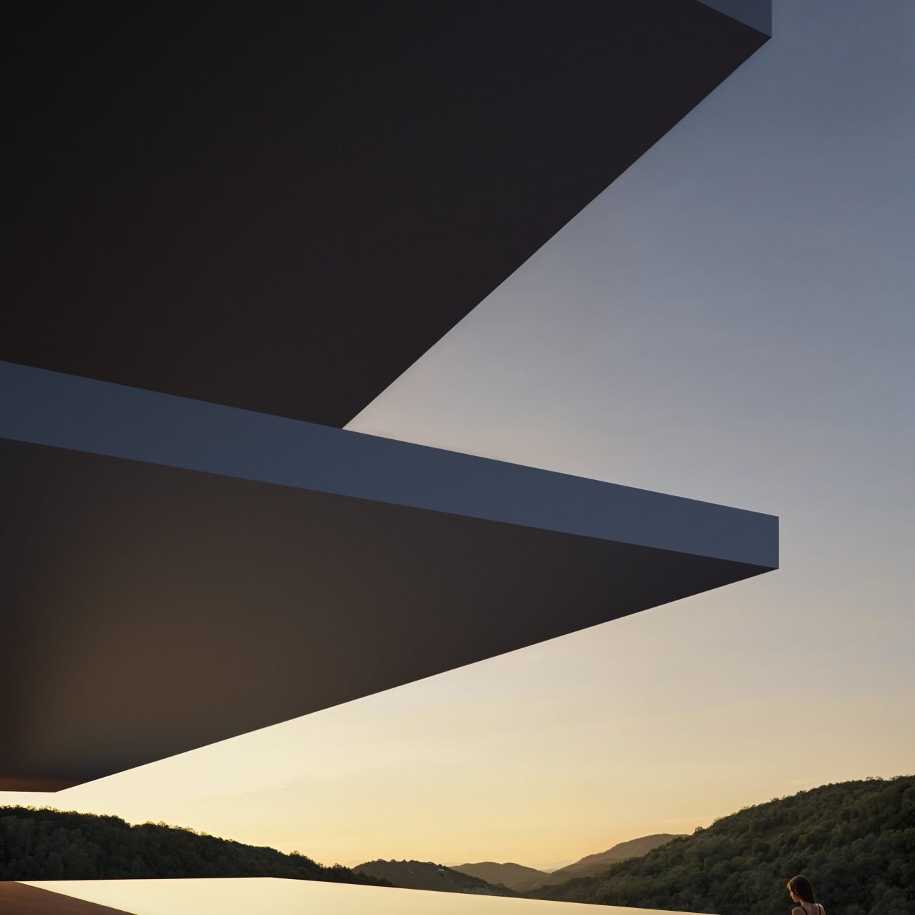 Mujer en una piscina infinita de una villa de lujo, con arquitectura moderna y vistas a montañas al atardecer.