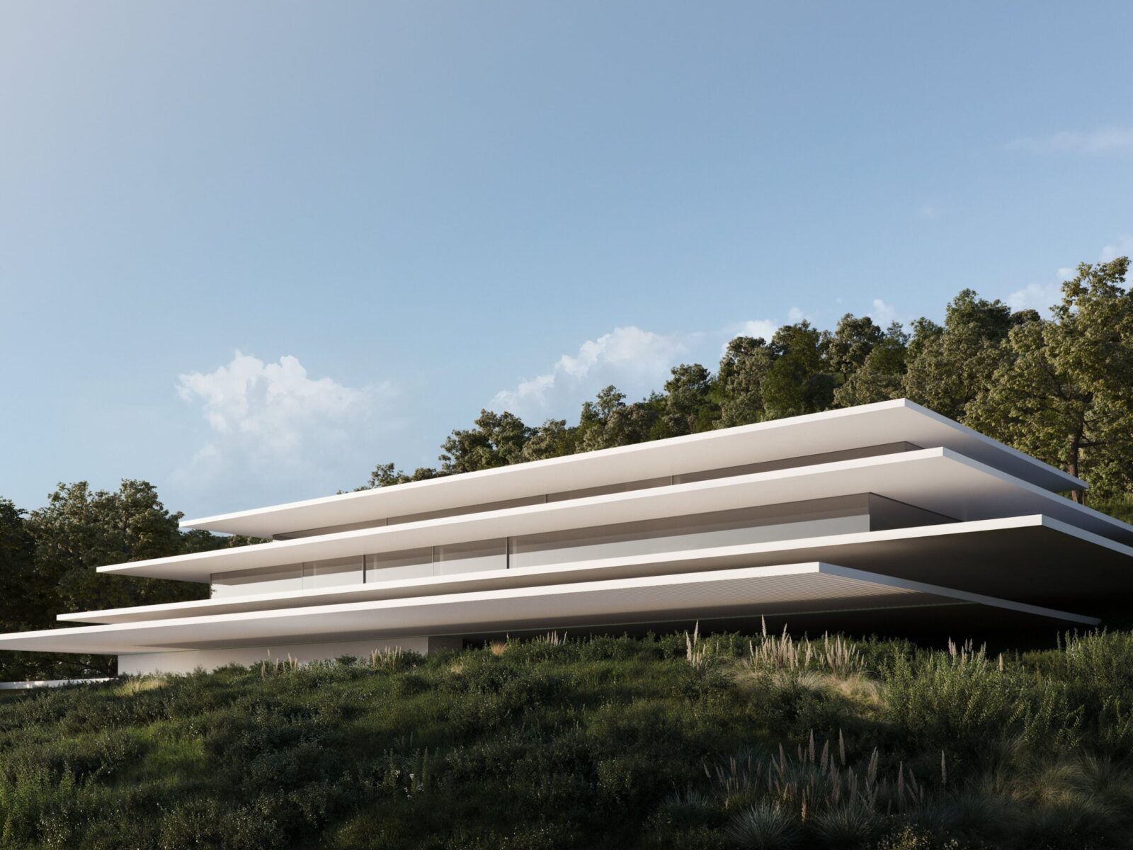 A multi-layered modern white luxury villa nestled into a green hillside with trees under a blue sky.