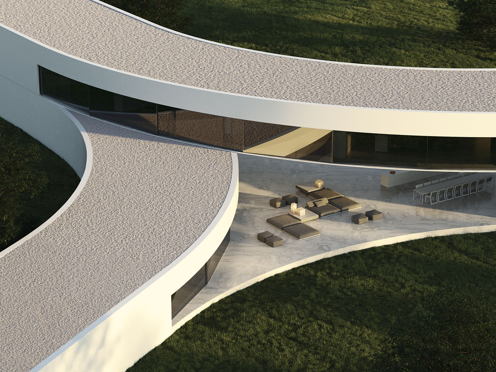 Aerial view of a curved luxury villa in Sotogrande with a textured roof, patio, and lounge area surrounded by green grass.
