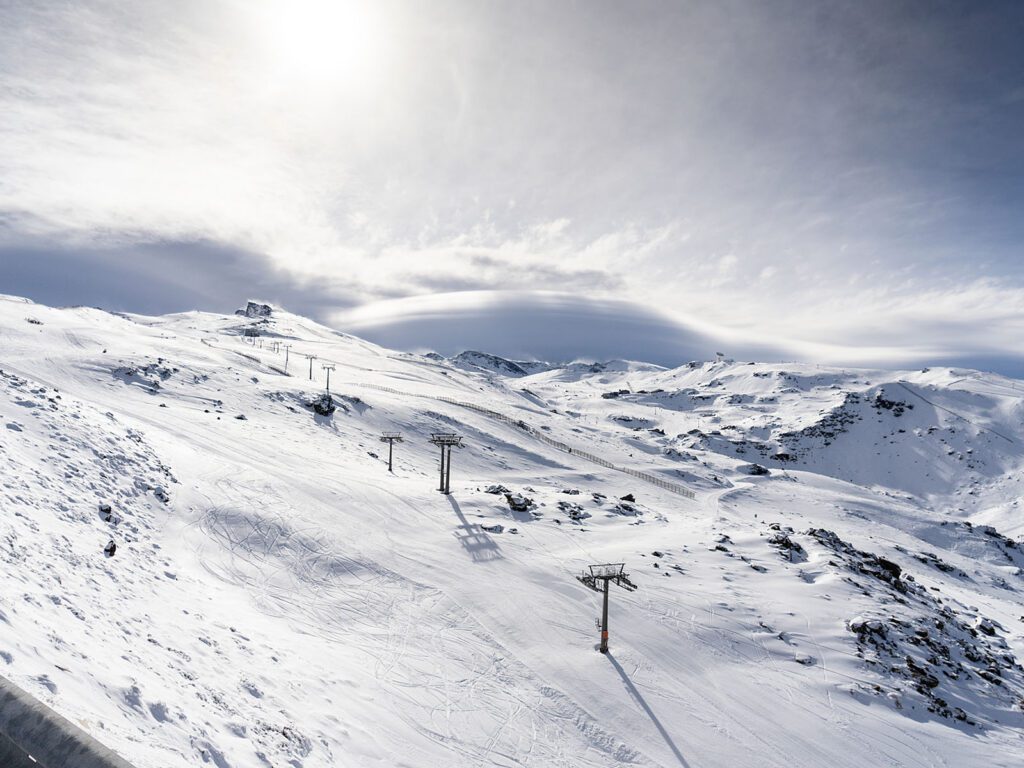 Snowy ski slopes and lifts under a bright sky, a winter activity for a La Zagaleta resident.