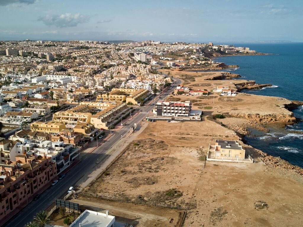 Costa del Sol coastal town with numerous properties and undeveloped land, relevant for homebuyers.