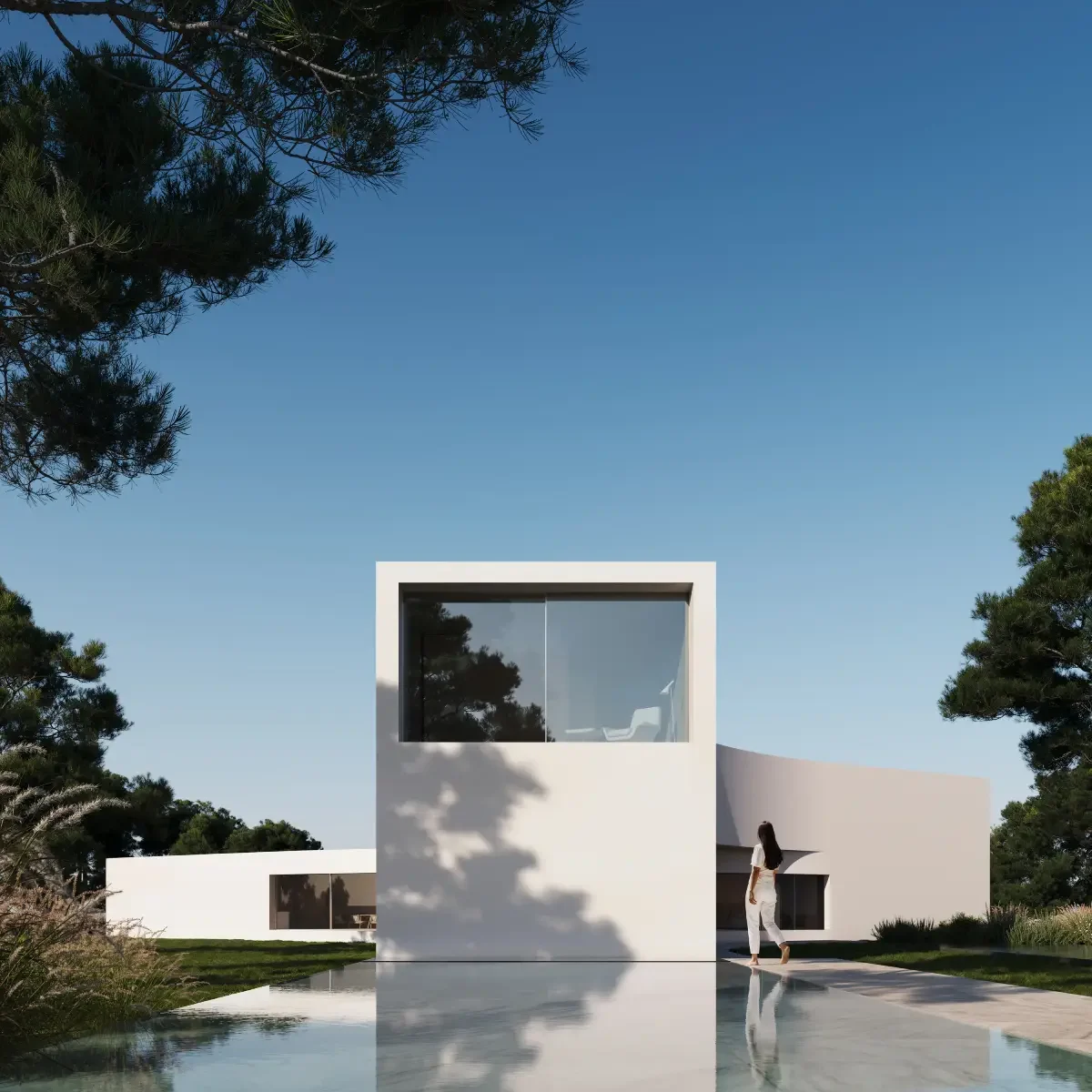 Modern white Sotogrande villa with a woman walking by a reflective pool, surrounded by pine trees under a clear blue sky.