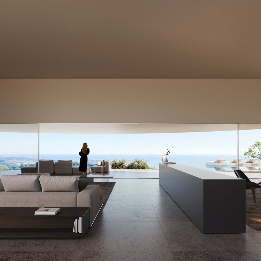 Modern living room of a luxury villa with a large sofa, dark counter, and floor-to-ceiling windows offering panoramic sea views.