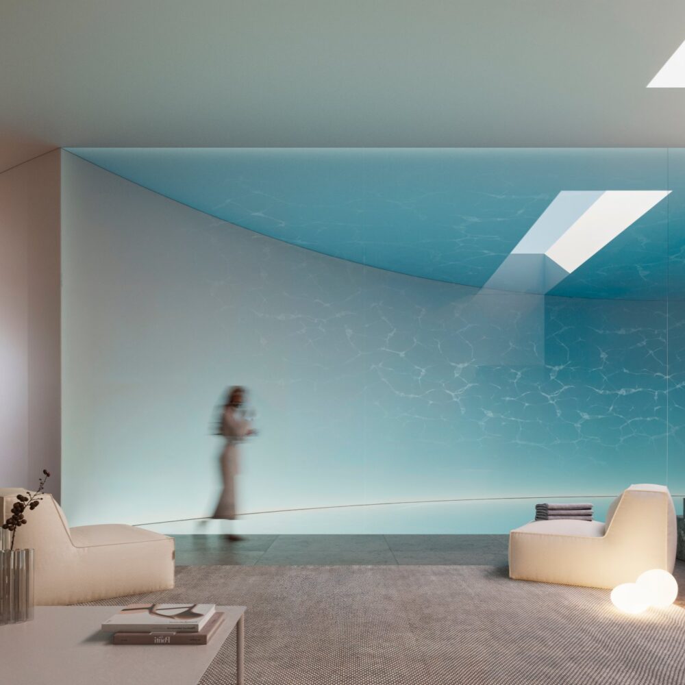 Modern indoor pool area with blue water, skylights, and minimalist lounge furniture in a luxury villa.