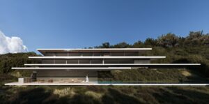 Moderna villa con terrazas voladizas, piscina infinita y zonas de estar al aire libre, entre la vegetación de Sotogrande.